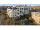 Modern condo building with cityscape backdrop, featuring multiple balconies and manicured landscaping at 130 Cherokee Rd # 104, Charlotte, NC 28207