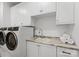 Clean, functional laundry room equipped with modern washer, dryer, and ample cabinet space at 130 Cherokee Rd # 104, Charlotte, NC 28207