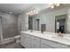 Bathroom featuring double sinks, gray tile floor, and a glass-enclosed shower at 1342 Galloway Rd # 132, Charlotte, NC 28262