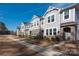 Exterior of townhomes featuring stone accents, manicured lawns, and a sidewalk for pedestrian access at 1342 Galloway Rd # 132, Charlotte, NC 28262