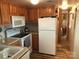 Galley kitchen with white appliances and wood cabinets at 140 Landlubber Trl # H73, Mount Gilead, NC 27306