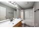 The remodeled bathroom features a shower-tub combo, modern vanity and black hardware at 300 Pine Meadows Cir, Hickory, NC 28601