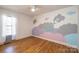 Bright bedroom features unique space-themed mural, wood floors, and ample natural light at 300 Pine Meadows Cir, Hickory, NC 28601