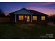 Charming brick home at dusk featuring a well-manicured lawn and warm light shining through the windows at 300 Pine Meadows Cir, Hickory, NC 28601