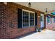 Close-up of front porch with brick facade, decorative flower pots, and white front door with glass accents at 300 Pine Meadows Cir, Hickory, NC 28601