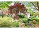 Charming brick home featuring mature trees, stone pathway, and lovely garden at 3024 Kern Dr, Salisbury, NC 28147