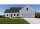 White farmhouse exterior with a two-car garage and landscaped lawn at 3073 Meadowcrest Dr # 26, Clover, SC 29710