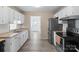 Well-lit kitchen with stainless steel appliances, white cabinetry, and easy access to dining area at 443 Picadilly Ln, Troutman, NC 28166