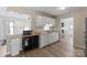 Cozy kitchen featuring white cabinetry, stainless steel sink, and modern backsplash at 443 Picadilly Ln, Troutman, NC 28166