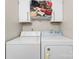 Well-lit laundry room features a washer, dryer, and overhead storage at 443 Picadilly Ln, Troutman, NC 28166