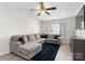 Comfortable living room featuring a large sectional couch, ceiling fan, and a mounted television at 443 Picadilly Ln, Troutman, NC 28166