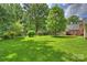Large backyard with plenty of green space and mature trees at 7135 Folger Dr, Charlotte, NC 28270