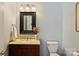 Charming powder room with a marble countertop, dark wood vanity, and decorative accents at 7135 Folger Dr, Charlotte, NC 28270