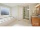 Bright bathroom featuring soaking tub, separate shower, single vanity, and tile floor at 7135 Folger Dr, Charlotte, NC 28270