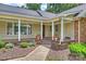 Inviting covered front porch with classic columns, a wood deck, and colorful planters at 7135 Folger Dr, Charlotte, NC 28270