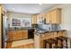 Stylish kitchen featuring wood cabinets, granite countertops, stainless steel appliances, and bar seating at 7135 Folger Dr, Charlotte, NC 28270