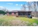 Large backyard with a mix of open grass and wooded areas, featuring a patio and screened porch at 8115 Kingsland Dr, Waxhaw, NC 28173