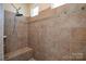 Large walk-in shower with tiled walls and built-in seat at 900 Raffaelo Vw, Mount Holly, NC 28120