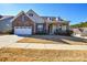 Two-story house with stone and siding exterior, two-car garage, and manicured lawn at 900 Raffaelo Vw, Mount Holly, NC 28120