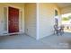 Front porch with red door and small black metal table and chairs at 900 Raffaelo Vw, Mount Holly, NC 28120