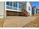 Brick paved patio with wooden stairs and sunroom with large windows at 900 Raffaelo Vw, Mount Holly, NC 28120