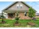 New construction home featuring a brick exterior, an outdoor patio, a grassy yard, and young trees at 9657 Liberty Hill Dr, Mint Hill, NC 28227