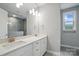 Elegant bathroom featuring double sinks, quartz counters, and large mirror at 9657 Liberty Hill Dr, Mint Hill, NC 28227