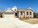 Charming two-story brick home with a three-car garage and well-manicured front lawn on a sunny day at 9657 Liberty Hill Dr, Mint Hill, NC 28227