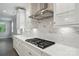 Modern kitchen with white cabinetry, marble backsplash, stainless steel range hood, and quartz countertops at 9657 Liberty Hill Dr, Mint Hill, NC 28227