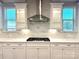 Gourmet kitchen featuring stainless steel hood, marble backsplash, and gas cooktop between illuminated cabinets at 9657 Liberty Hill Dr, Mint Hill, NC 28227
