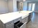 Kitchen island with white countertop, gray cabinets, a farmhouse sink and built in trash receptacle at 9657 Liberty Hill Dr, Mint Hill, NC 28227