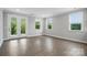 Bright and spacious living room with hardwood floors, three large windows, and double glass doors at 9657 Liberty Hill Dr, Mint Hill, NC 28227
