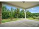 Spacious outdoor patio overlooking a green backyard with a black fence surrounded by mature trees at 9657 Liberty Hill Dr, Mint Hill, NC 28227
