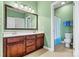 Bathroom featuring green walls, double vanity with a large mirror, and a shower with a decorative curtain at 103 Glenholden Ln, Mooresville, NC 28115