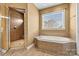 Relaxing bathroom with a soaking tub, glass shower, and natural light at 103 Glenholden Ln, Mooresville, NC 28115