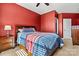 Bedroom featuring red walls, a ceiling fan, and a bed with blue and red bedding at 103 Glenholden Ln, Mooresville, NC 28115