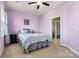 Bedroom with lavender walls, carpet, a ceiling fan, and a comfortable bed with soft bedding at 103 Glenholden Ln, Mooresville, NC 28115