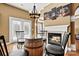 Dining area with a unique wine-barrel table, fireplace, and views to the outdoor patio at 103 Glenholden Ln, Mooresville, NC 28115