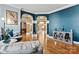 Stylish living room with hardwood floors, blue accent wall, and elegant archway to dining area at 103 Glenholden Ln, Mooresville, NC 28115