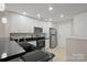 Modern kitchen with white cabinets, black countertops, and stainless steel appliances at 10841 Twisted Bark Ln, Charlotte, NC 28213