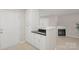 White kitchen cabinets, black countertops, and a view into the living room at 10841 Twisted Bark Ln, Charlotte, NC 28213