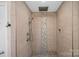 Large walk-in shower with pebble tile accent at 109 Washburn Range Dr, Mooresville, NC 28115