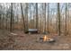 Stone fire pit with wood pile in woods at 11270 Widenhouse Rd, Midland, NC 28107