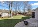 Landscaped backyard with a shed, patio, and fire pit at 114 Runningdeer Dr, Mooresville, NC 28117