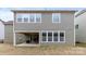 Back exterior of a home with multiple windows, gray siding, and a covered patio at 11519 Sweet Birch Ln, Charlotte, NC 28278