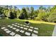 Expansive backyard with a stone pathway leading to a cozy fire pit near a pond at 11519 Sweet Birch Ln, Charlotte, NC 28278