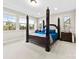 Spacious bedroom featuring a four-poster bed, neutral carpet, and bright windows at 11519 Sweet Birch Ln, Charlotte, NC 28278