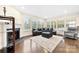 Sun-drenched living room with a cozy fireplace, comfortable seating, and hardwood floors at 11519 Sweet Birch Ln, Charlotte, NC 28278