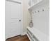 White mudroom with bench, cubbies, and hooks, hardwood floor at 11519 Sweet Birch Ln, Charlotte, NC 28278