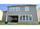 Rear exterior of a two-story home showcasing a covered patio with outdoor furniture at 11519 Sweet Birch Ln, Charlotte, NC 28278